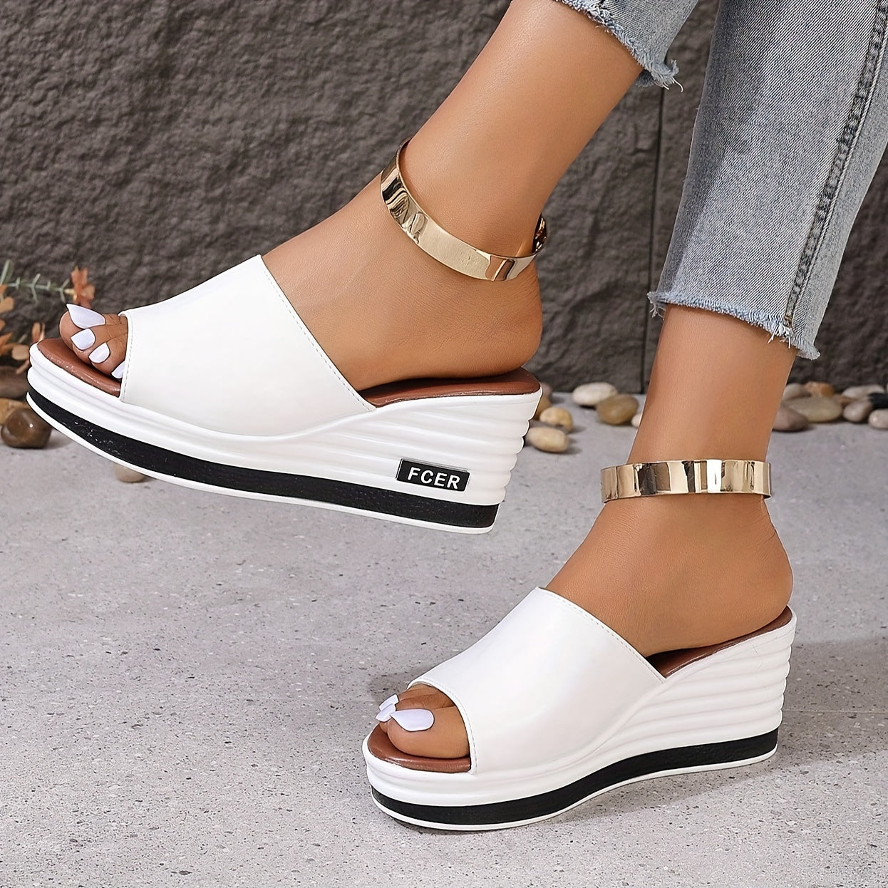 Diseño slip-on de punta abierta en blanco sólido, realzado con un elegante acento dorado en el tobillo. Con suela gruesa de poliuretano para un soporte duradero, son perfectas para un estilo casual y sofisticado.