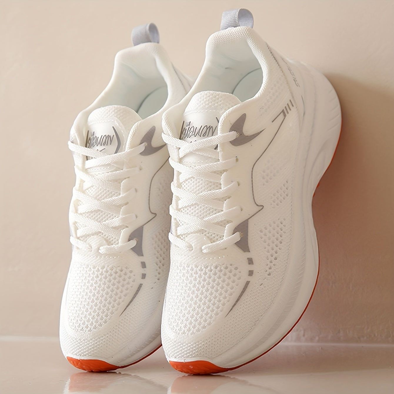 Zapatillas deportivas para mujer, transpirables y cómodas, de corte bajo en blanco con suela naranja. Con soporte estabilizador, ideales para todas las estaciones. Parte superior de tela transpirable y suela de goma para un rendimiento casual y seguro.